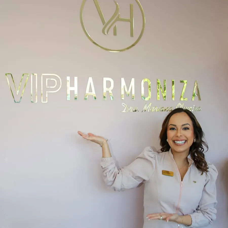 Dra. Mariana Oliveira na Vip Harmoniza — ao fundo, a parede com o logo dourado da clínica